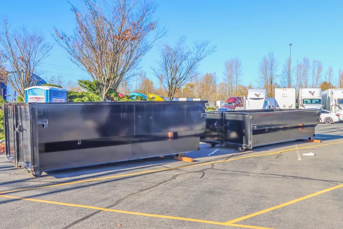 Professional dumpster rental service with roll-off container on residential driveway in Tewksbury